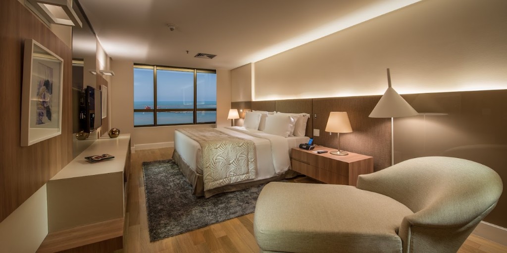 Ocean-view guest room at Gran Marquise with a king bed and lounge chair